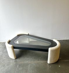 a black and white coffee table sitting on top of a cement floor next to a wall