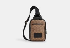 a brown and black coach bag on a white background with the strap hanging down to it's side