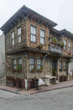 an old wooden house with many windows and balconies on the second floor is shown