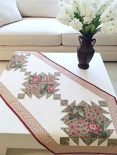 a vase with white flowers sitting on top of a coffee table next to a couch