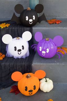 three halloween pumpkins with faces on them sitting on the steps next to each other