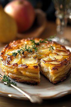 a plate with some food on it and silverware next to an apple in the background