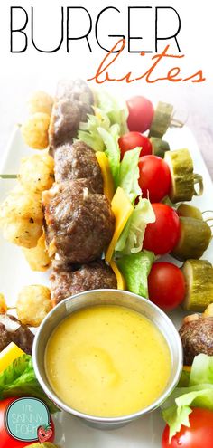 a white plate topped with meat and veggies next to a bowl of sauce