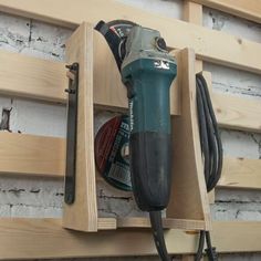 a driller and power tool are in a wooden holder on a wall with wood planks