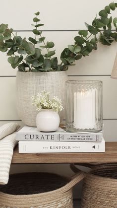 a couple of books sitting on top of a table next to a vase filled with flowers