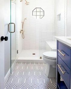 a bathroom with a toilet, sink and shower in it's own area that has geometric tiles on the floor