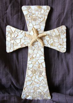 a cross made out of shells with a starfish on it