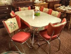 a dining room table with chairs and a teddy bear on the center piece in front of it