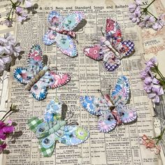 several colorful butterflies sitting on top of an old book