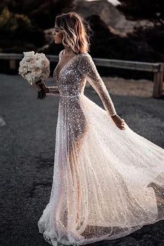 a woman in a wedding dress is walking down the street with her bouquet and flowers