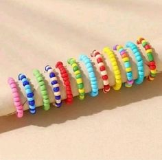 a row of colorful bracelets sitting on top of a white sheet