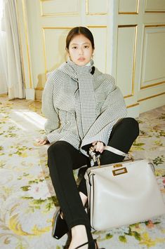 a woman sitting on the floor holding a purse