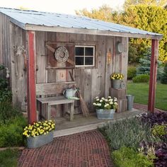 a small wooden shed with flowers in the front and side garden area on either side