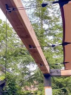 an outdoor dining area with tables and chairs under the awnings, surrounded by trees