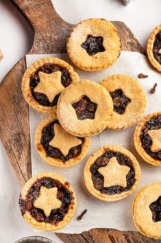 several small pies on a wooden cutting board next to a bowl of chocolate chips