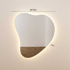 a white heart shaped mirror on the wall with measurements for it's size and width