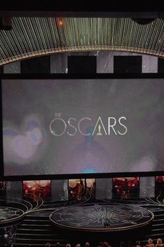 the oscars stage is shown in front of an audience with their hands on their hips