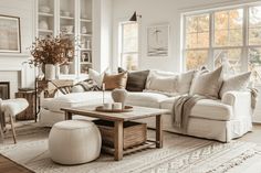 a living room filled with furniture and a fire place in front of a large window