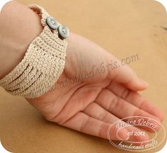 a baby's hand holding onto a bracelet with buttons