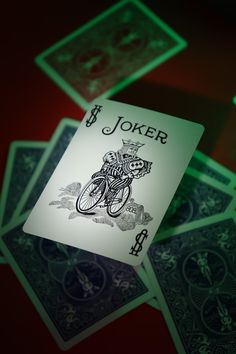 a joker playing card sitting on top of cards