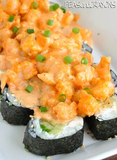 some sushi with sauce and green onions on the top is sitting on a white plate