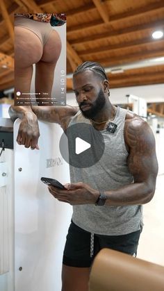 a man standing next to a white refrigerator holding a cell phone