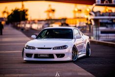 a white car parked in front of a bridge