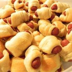 a white plate topped with hot dogs covered in crescented buns on top of each other