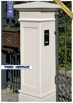 a tall white mailbox sitting next to a fence