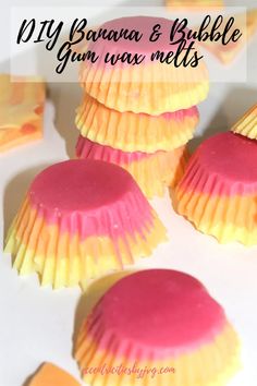 some pink and yellow cupcakes with icing on them sitting next to each other