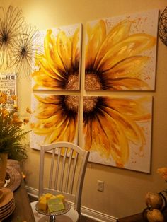 three sunflowers are hanging on the wall above a dining room table and chairs