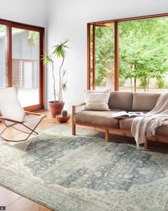 a living room filled with furniture and lots of window sill space next to a couch