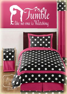 a bedroom with pink and black bedding, polka dot curtains and wall decals