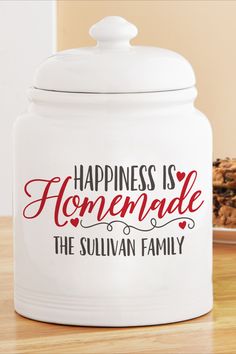 a white canister with the words happiness is homemade on it next to a plate of cookies