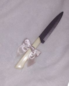 a knife with a bow on it laying on a blanket