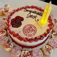 a cake that is sitting on top of a table with cupcakes around it