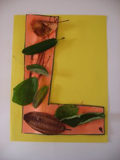 the letter e is made up of leaves and twigs on a yellow paper background with an orange rectangle