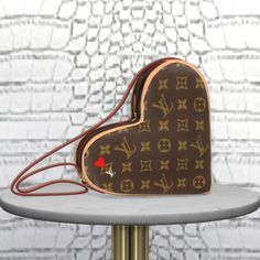 a heart shaped purse sitting on top of a table