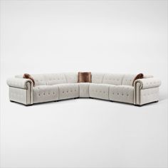 a white sectional couch with two pillows on it's back and one arm facing the camera