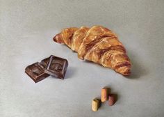 a croissant, chocolate and almonds are on the table next to each other