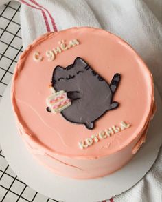 a pink cake with a cat on it