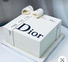 a white box with the word dior on it and a bow tied around it