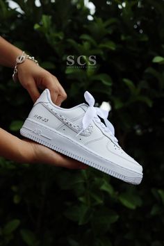 a person holding a white nike air force shoe