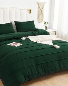 a bed with green sheets and pillows in a room