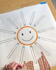 a child's hand holding dominos in front of a drawing of a smiley face