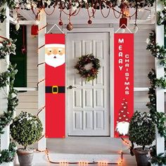 christmas decorations on the front door of a house with santa clause and wreaths hanging from it