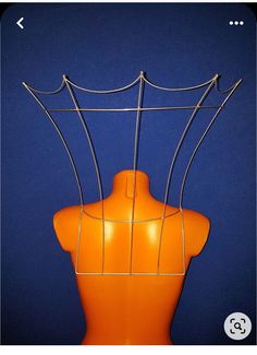 an orange mannequin with wire on it's back