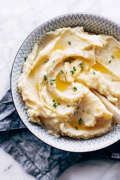 a bowl filled with mashed potatoes on top of a white and blue table cloth