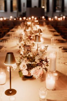 a long table is set with candles and flowers for a formal dinner or function in the evening