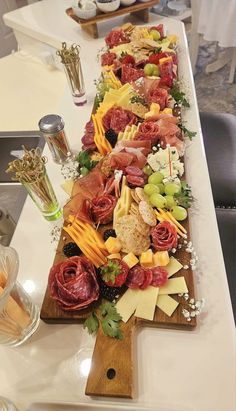 a long platter filled with lots of different types of cheeses and meats